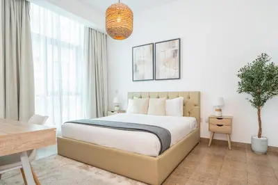a bedroom with a bed and a table and a desk at Luxury 1BR with Pool, Gym Canal & Burj Khalifa view in Dubai