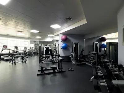 a gym with lots of cardio equipment in a room at Stylish Apartment with Pool, Gym and Skyline View Dubai Gate in Dubai