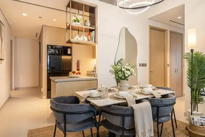 a dining room with a table and blue chairs at Vida Dubai Mall! Excellent Amenities! Direct Access To Dubai Mall in Dubai