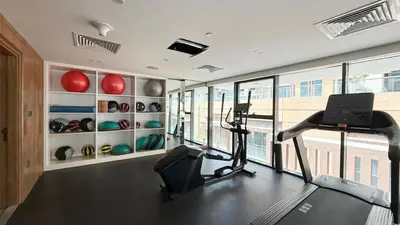 a room with a gym with a treadmill and vases at Downtown culture village escape in Dubai