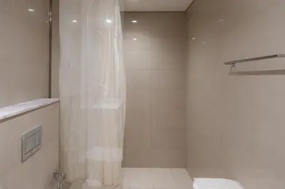 a bathroom with a shower curtain and a toilet at Modern 1BR - Fitness & Swimming Pool Access in Dubai