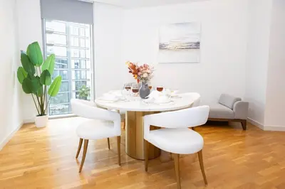 a white dining room with a white table and chairs at Spacious Luxury 1BR Modern Design Bluewaters in Dubai