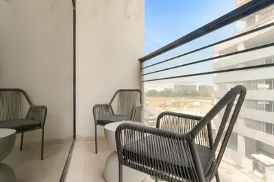 a balcony with two chairs and a large window at Silkhaus Classic 1BDR Stay in Jumeirah Village in Dubai