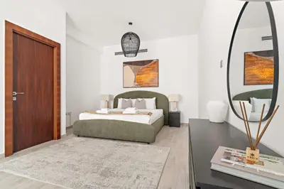 a bedroom with a bed and a table with a mirror at Silkhaus Classic 1BDR Stay in Jumeirah Village in Dubai