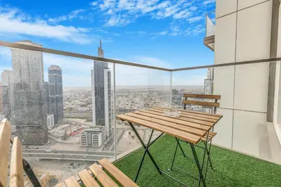 a balcony with a wooden table and a view of the city at Modern 1BR apartment in Burj Crown in Dubai