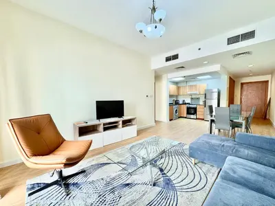 a living room with a couch and a tv at Homes2Retreat - JVC Charm - 1BR Apt with Private Balcony in Dubai