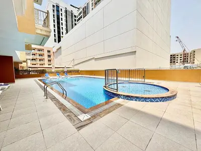 a swimming pool in the middle of a building at Homes2Retreat - JVC Charm - 1BR Apt with Private Balcony in Dubai