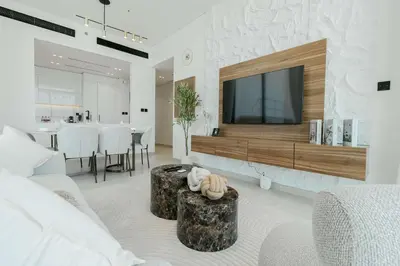 a living room with a tv on a wall at TRPS - Binghatti Onyx JVC - Luxury 2BR with Private Pool in Dubai