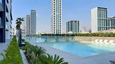 a large swimming pool in a city with tall buildings at TRPS - Binghatti Onyx JVC - Luxury 2BR with Private Pool in Dubai