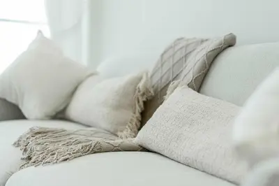 a white couch with pillows on top of it at TRPS - Binghatti Onyx JVC - Luxury 2BR with Private Pool in Dubai