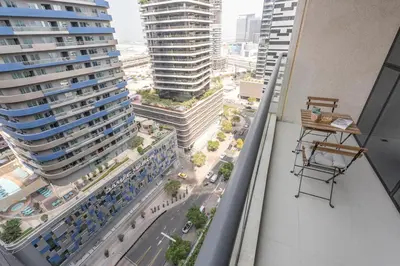 an apartment balcony with a view of a city at Dunya Tower Downtown 1BR Balcony Pool View 2Min to Dubai Mall in Dubai