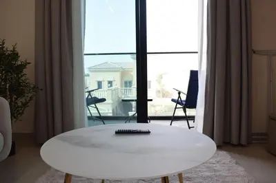 a white coffee table in front of a large window at Binghatti Dusk Studio with Gym &Pool in Dubai