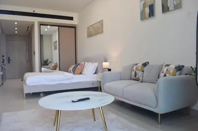 a living room with a couch and a table at Binghatti Dusk Studio with Gym &Pool in Dubai