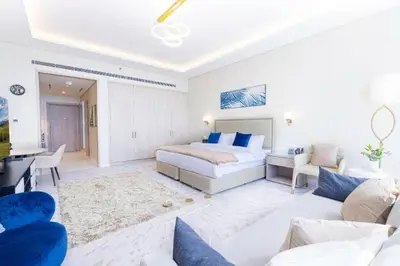 a bedroom with a bed and a living room at Scenic Studio at Palm Tower in Dubai