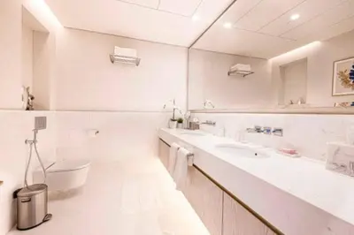 a white bathroom with a sink and a toilet at Scenic Studio at Palm Tower in Dubai