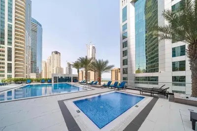 a large swimming pool in a city with tall buildings at Bright & Stylish Studio with Marina Views in Dubai