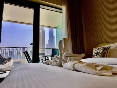 a towel animal sitting on a bed in a hotel room at Burj Khalifa View Luxe 2BR x Connected to Dubai Mall in Dubai