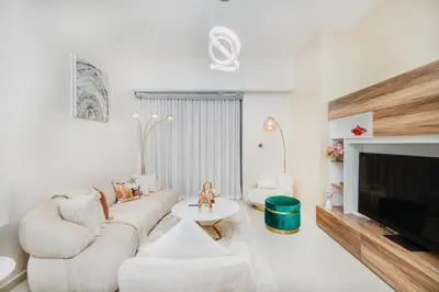 a living room with a couch and a tv at Iconic Views 2BR Burj Khalifa and Fountain in Dubai