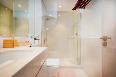a white bathroom with a shower and a toilet at Iconic Views 2BR Burj Khalifa and Fountain in Dubai