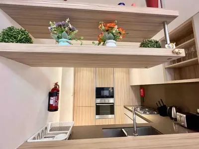 a kitchen with wooden shelves with flowers on it at Spacious & Modern 1BR in Wilton Terraces in Dubai