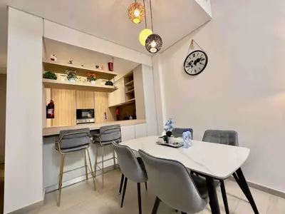 a dining room with a white table and chairs at Spacious & Modern 1BR in Wilton Terraces in Dubai