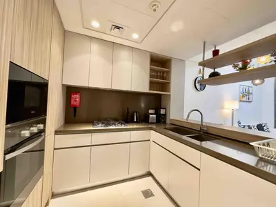 a kitchen with white cabinets and a sink at Spacious & Modern 1BR in Wilton Terraces in Dubai