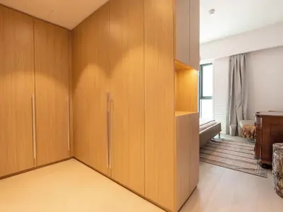 a room with wooden cabinets and a bedroom at Modern Neoclassical 1BR - Berkeley Place Dubai in Dubai