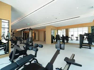 a gym with cardio equipment in a hotel room at Modern Neoclassical 1BR - Berkeley Place Dubai in Dubai