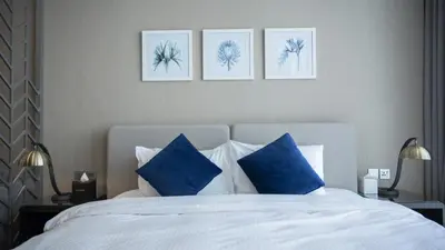 a bedroom with a white bed with blue pillows at Luxury Studio in Heart of Dubai in Dubai