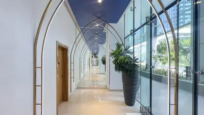 a hallway with a plant in a large vase at Luxury Studio in Heart of Dubai in Dubai