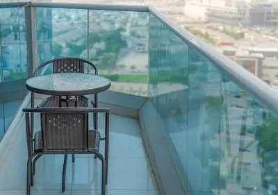 a table and chair on the balcony of a building at Lux JVT Resort Pools Spa Gym Kids Play in Dubai
