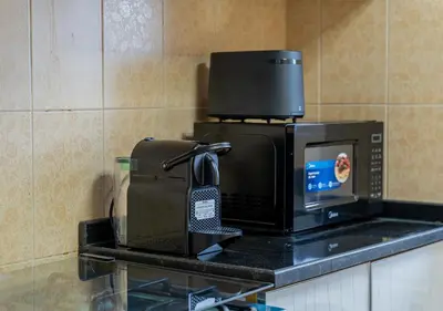 a microwave sitting on a counter next to a toaster at Lux JVT Resort Pools Spa Gym Kids Play in Dubai