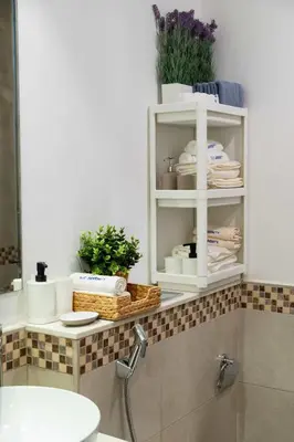 a bathroom with a sink and a shelf with towels at Cozy Burj Khalifa View Retreat in Dubai