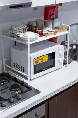 a kitchen with a microwave and a stove at Cozy Burj Khalifa View Retreat in Dubai