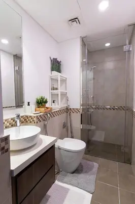 a bathroom with a toilet and a sink and a shower at Cozy Burj Khalifa View Retreat in Dubai