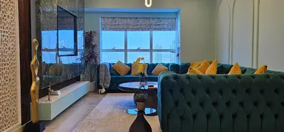 a living room with a blue couch and a window at Homeeza Luxury 2BR Apartment Sea Views Dubai Marina in Dubai