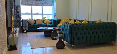 a living room with a green couch and a table at Homeeza Luxury 2BR Apartment Sea Views Dubai Marina in Dubai