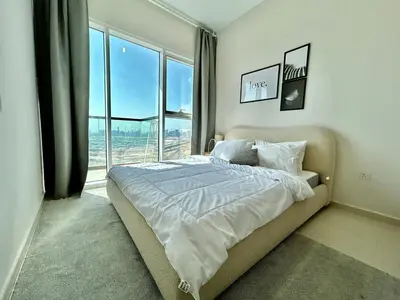 a bedroom with a bed and a large window at Homes2Retreat - Golf & Desert Views - Luxe 1BR Escape in Dubai