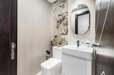 a bathroom with a toilet and a sink and a mirror at ALiving Modern 1BR I Private Pool I Opalz by Danube- 1704 in Dubai