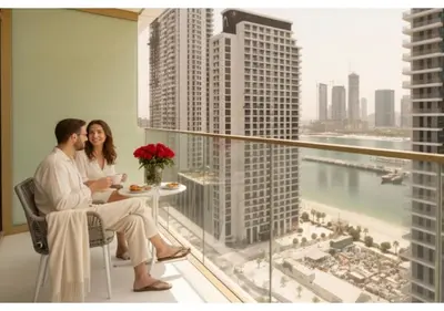 a man and woman sitting at a table in a hotel room at KeyRock - 1BR with Sea & Palm Jumeirah Views in Dubai