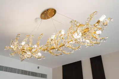 a chandelier hanging from a ceiling with a clock at KeyRock - 1BR with Sea & Palm Jumeirah Views in Dubai
