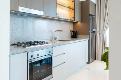 a kitchen with white cabinets and a stove at KeyRock - Sea View Stay with Pool Access in Dubai