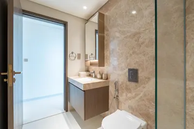 a bathroom with a toilet and a glass shower at KeyRock - Sea View Stay with Pool Access in Dubai