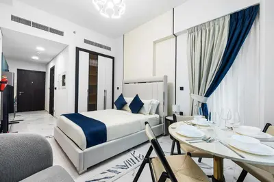 a hotel room with a bed and a dining room at ALiving Modern Studio I Private Pool I Opalz by Danube- 1308 in Dubai