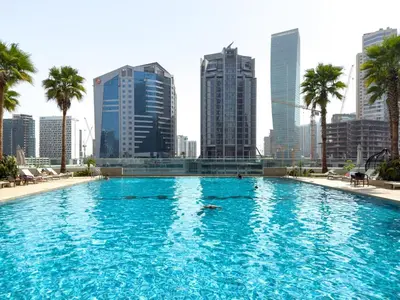 a swimming pool with a city skyline in the background at GuestReady - Canal View | Studio + Sofa Bed in Dubai