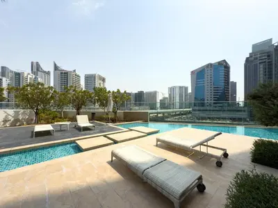 a swimming pool with benches and a city skyline at GuestReady - Canal View | Studio + Sofa Bed in Dubai