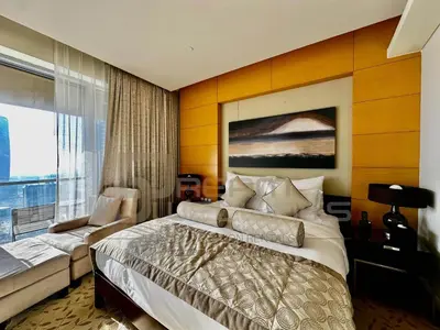a bedroom with a bed and a large window at Kempinski Central Avenue Studio Burj view in Dubai