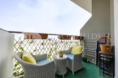 a balcony with wicker chairs and a table at Bloomfields Stylish Stu Laya Heights in Dubai