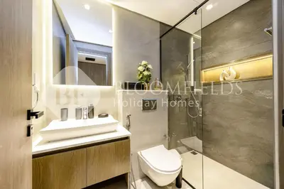 a bathroom with a toilet and a sink and a shower at Bloomfields Stylish Stu Laya Heights in Dubai