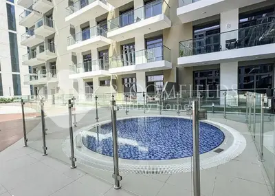 a building with a swimming pool in front of a building at Bloomfields Stylish Stu Laya Heights in Dubai